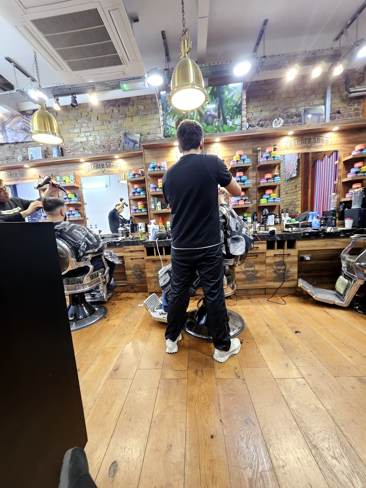 The shop floor with a barber at the chair